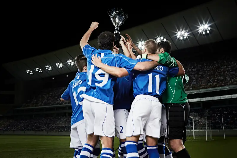 Soccer team celebrating trophy
